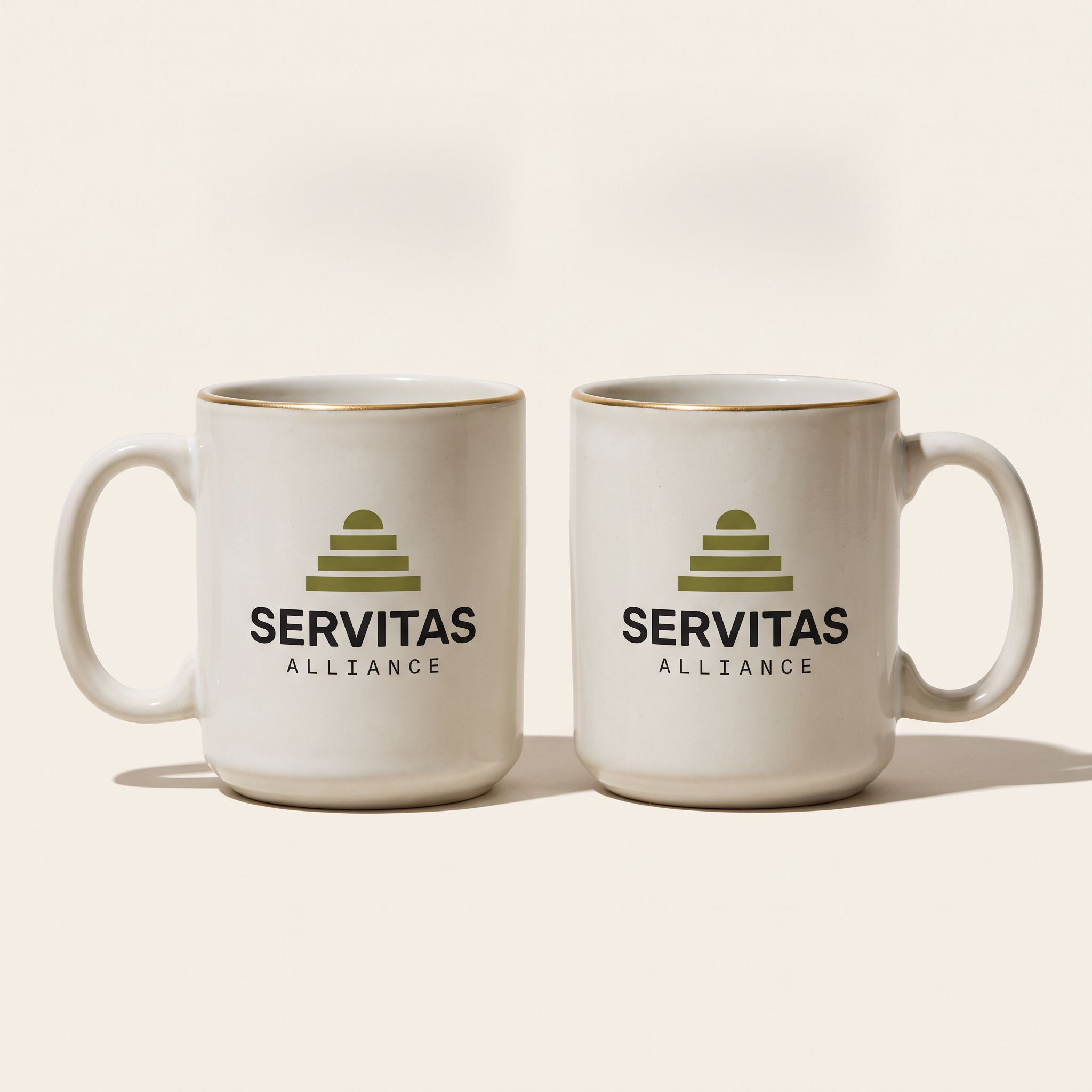 Servitas Ceramic Mug Pair: Two stoneware mugs, bone glaze with an olive mark, for coffee before the shift.