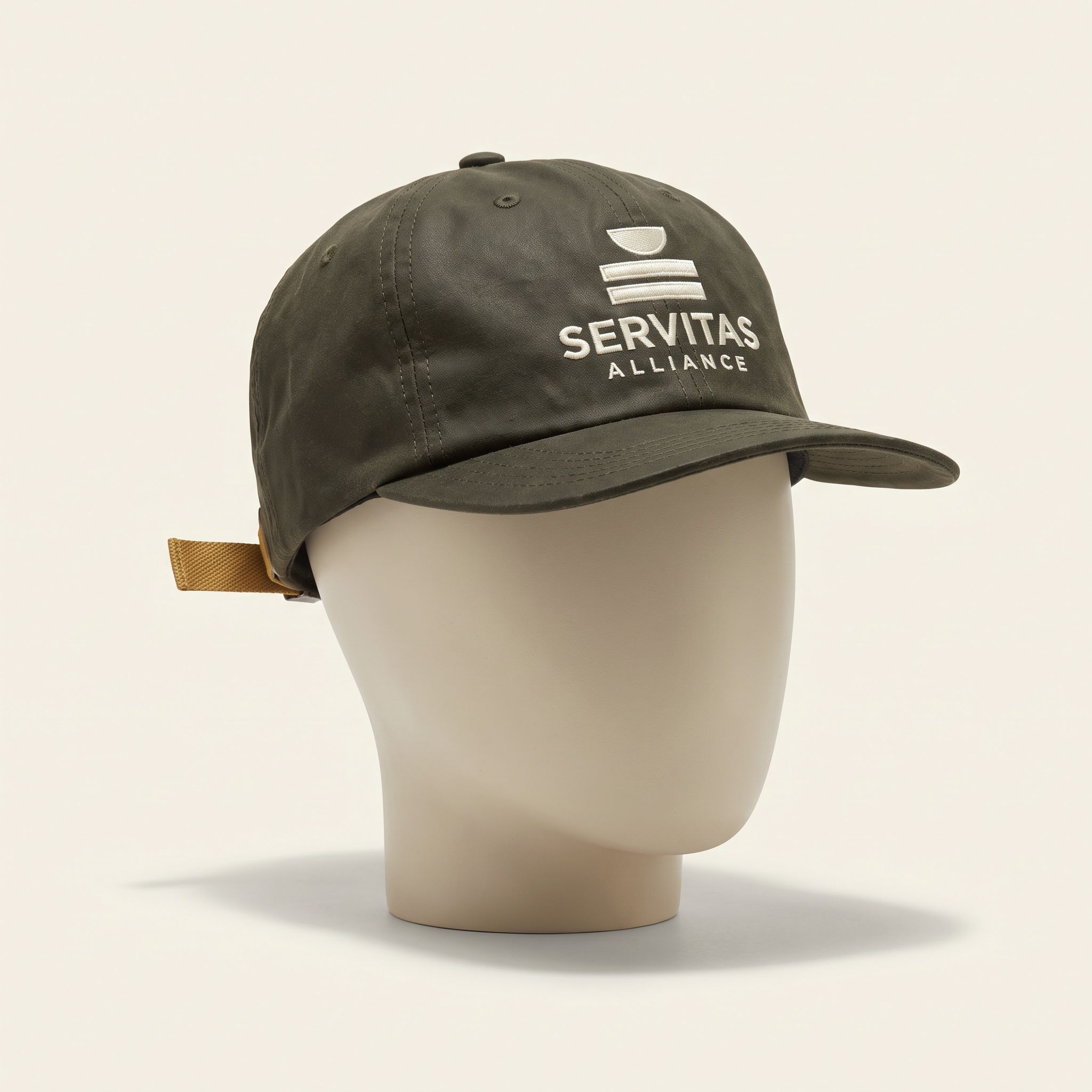 Servitas Field Cap: Unstructured waxed cotton cap in olive with the mark stitched on the front.